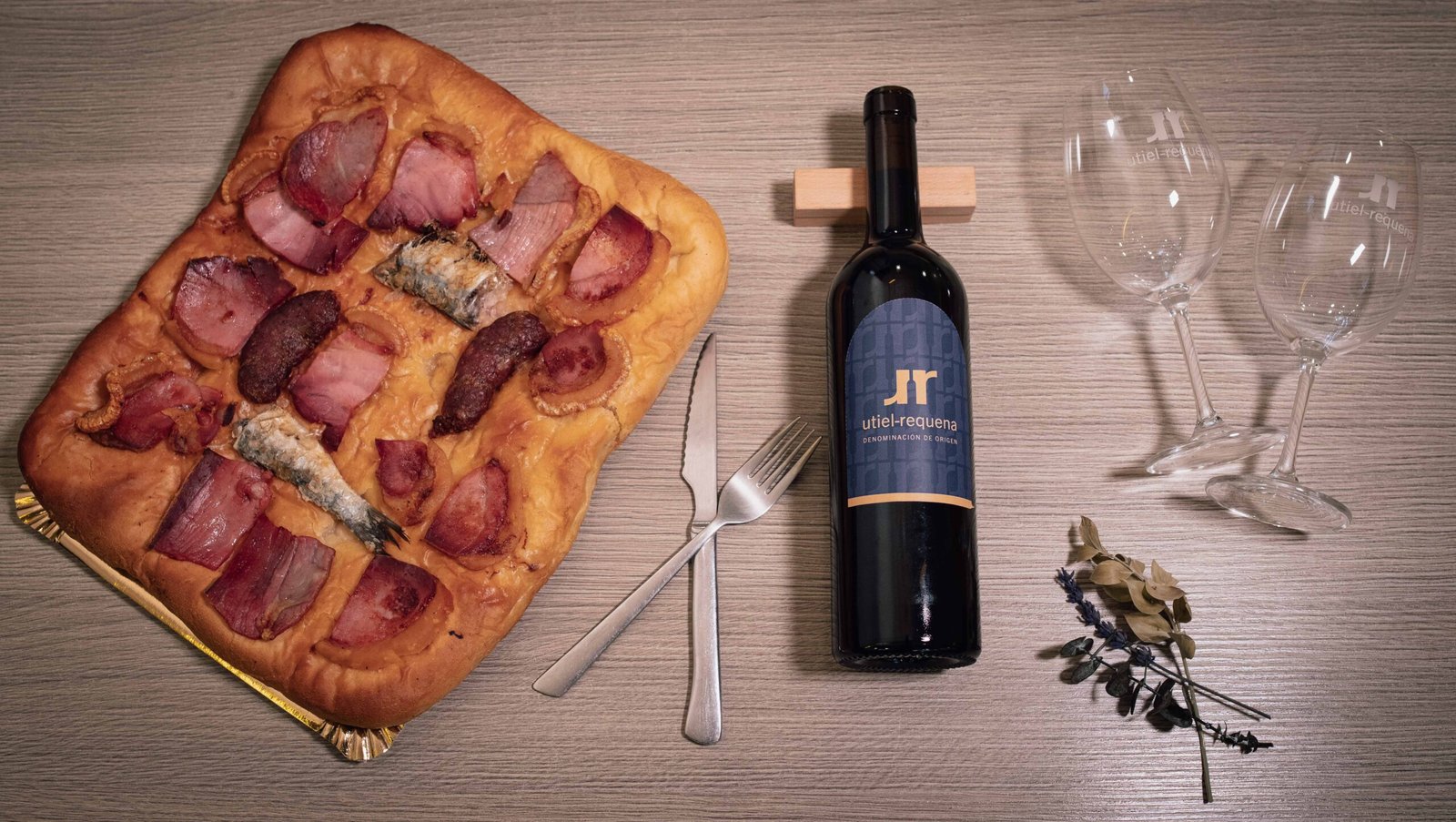 Coca tradicional con embutido y una botella de vino de la DO Utiel-Requena