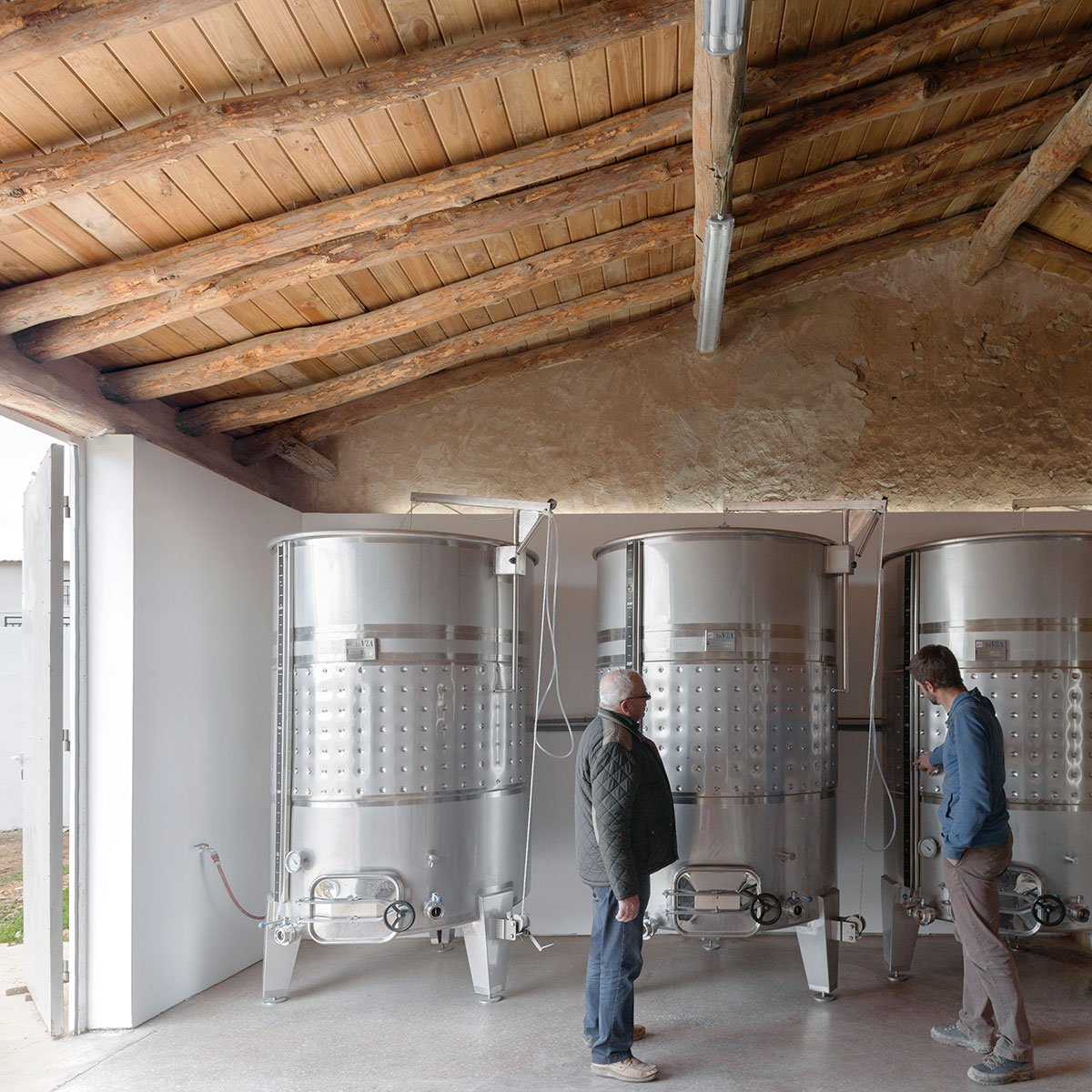 Depósitos de acero inoxidable bajo el techo de madera restaurado de Bodega Dussart Pedrón
