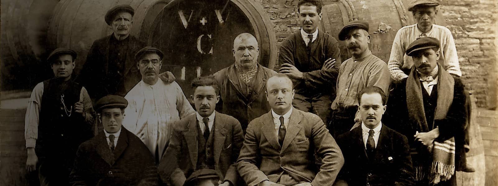 Fotografía histórica de los bodegueros de la familia Valsangiacomo junto a las barricas