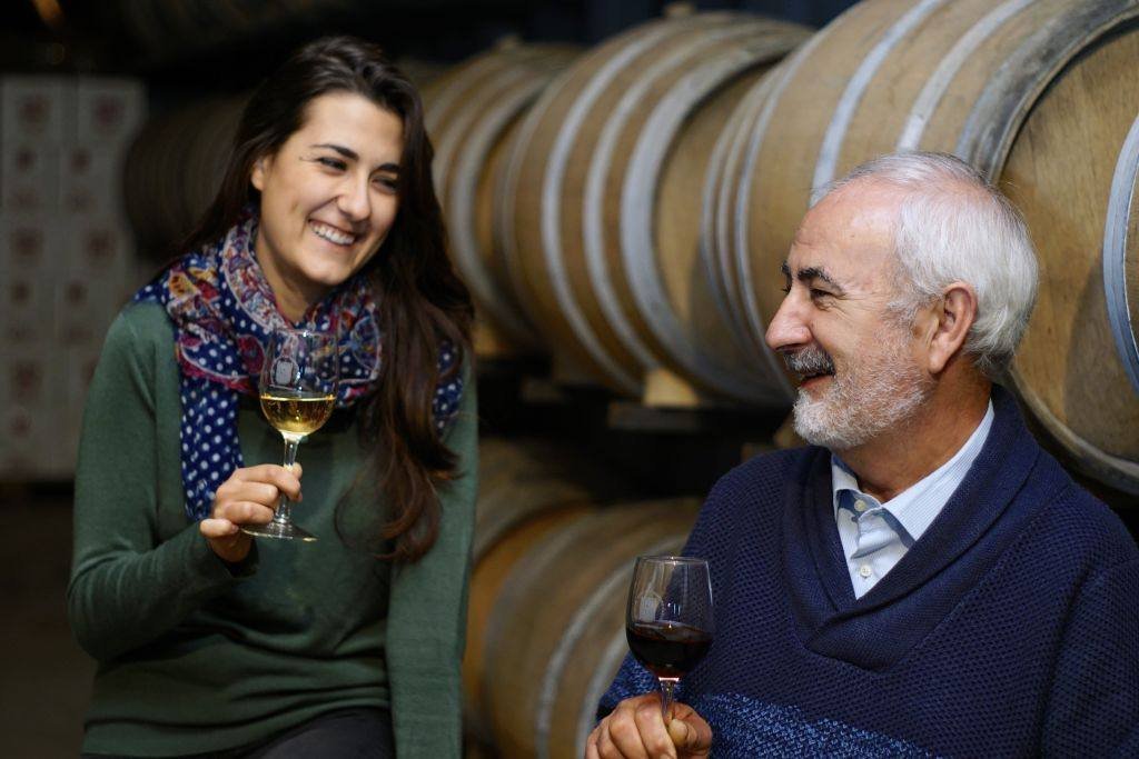 Visitantes catando vino junto a las barricas en una bodega de Utiel-Requena