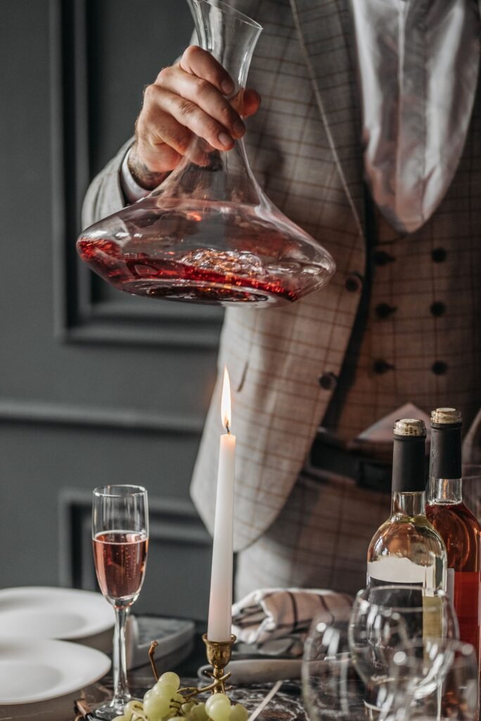 Vino tinto pasado a un decantador durante el ritual de decantar el vino
