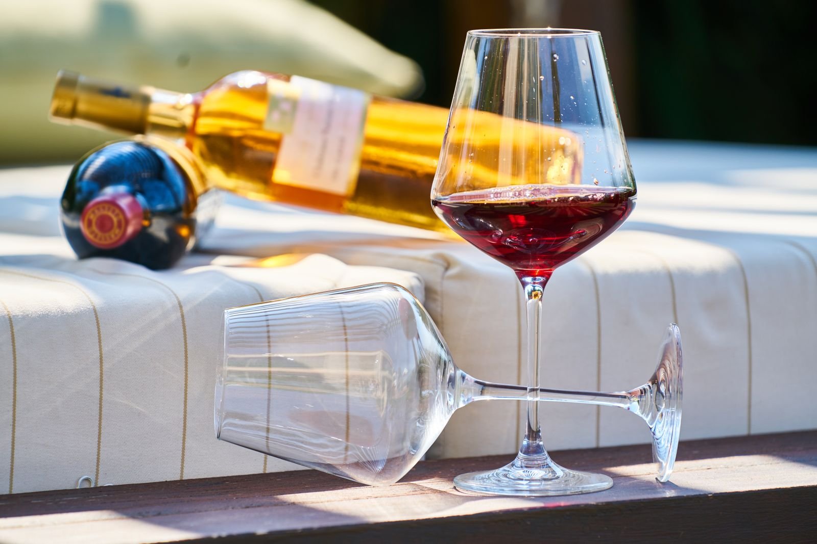 Copa de vino tinto a contraluz junto a la botella para comprobar su color