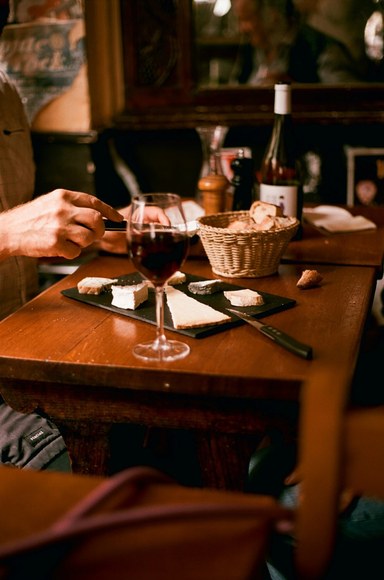 Copa de vino tinto acompañada de pan y queso en una comida