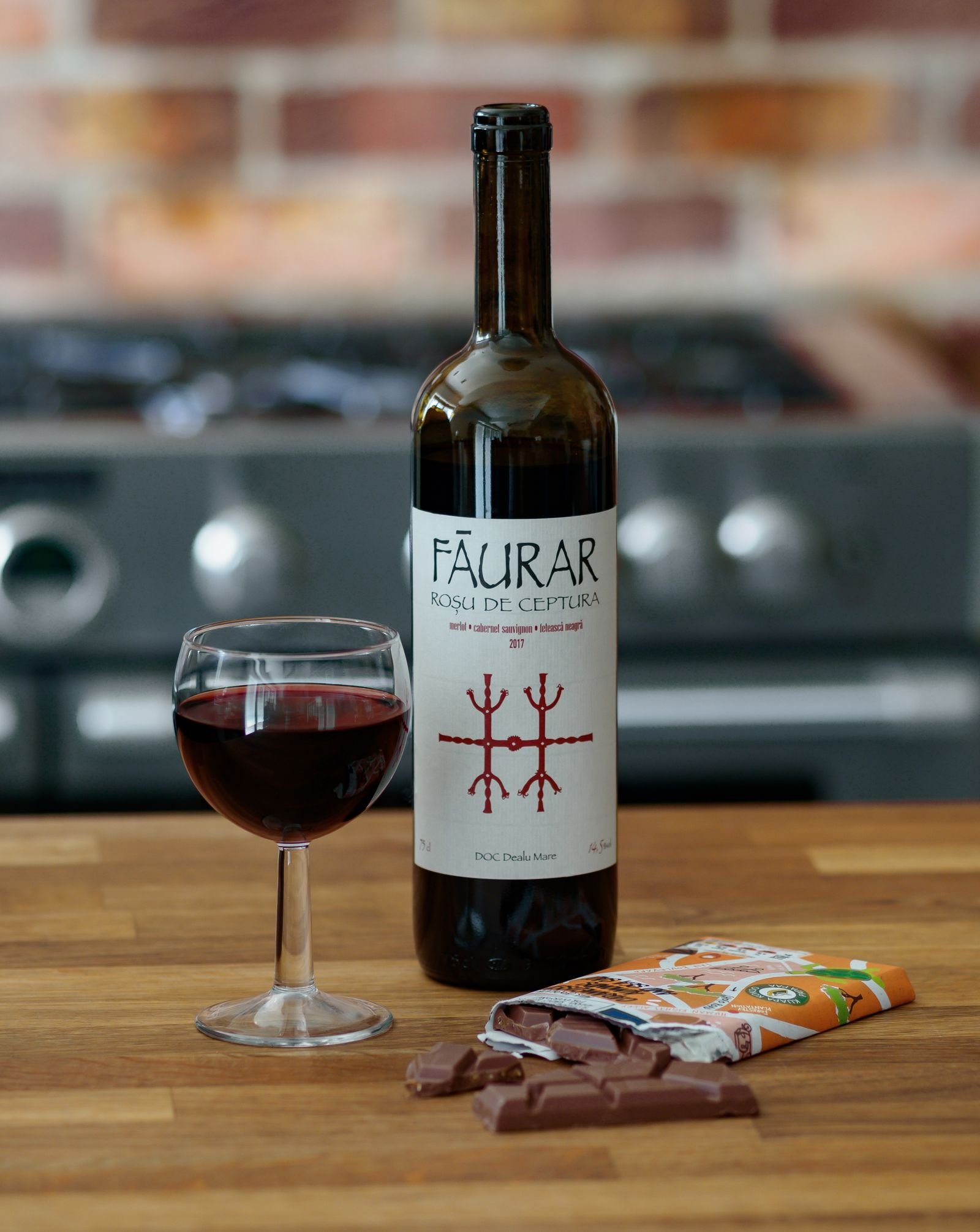 Chocolate con leche junto a una copa de vino tinto joven