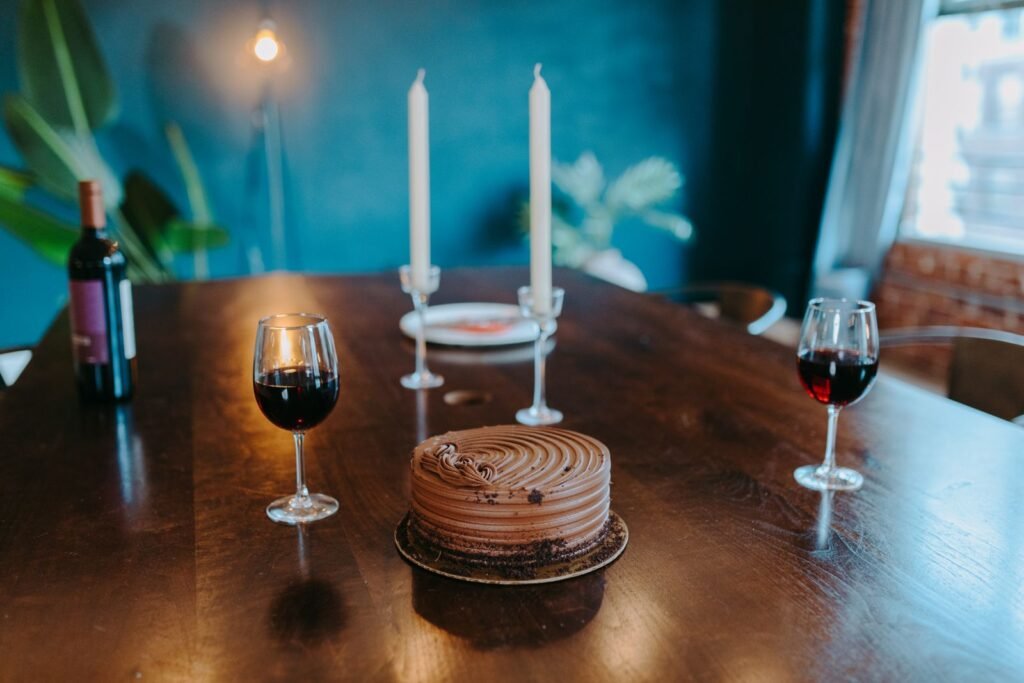 Copa de vino tinto junto a una tarta de chocolate en una sobremesa