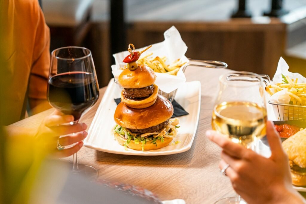 Hamburguesa casera con una copa de vino tinto en una mesa de verano