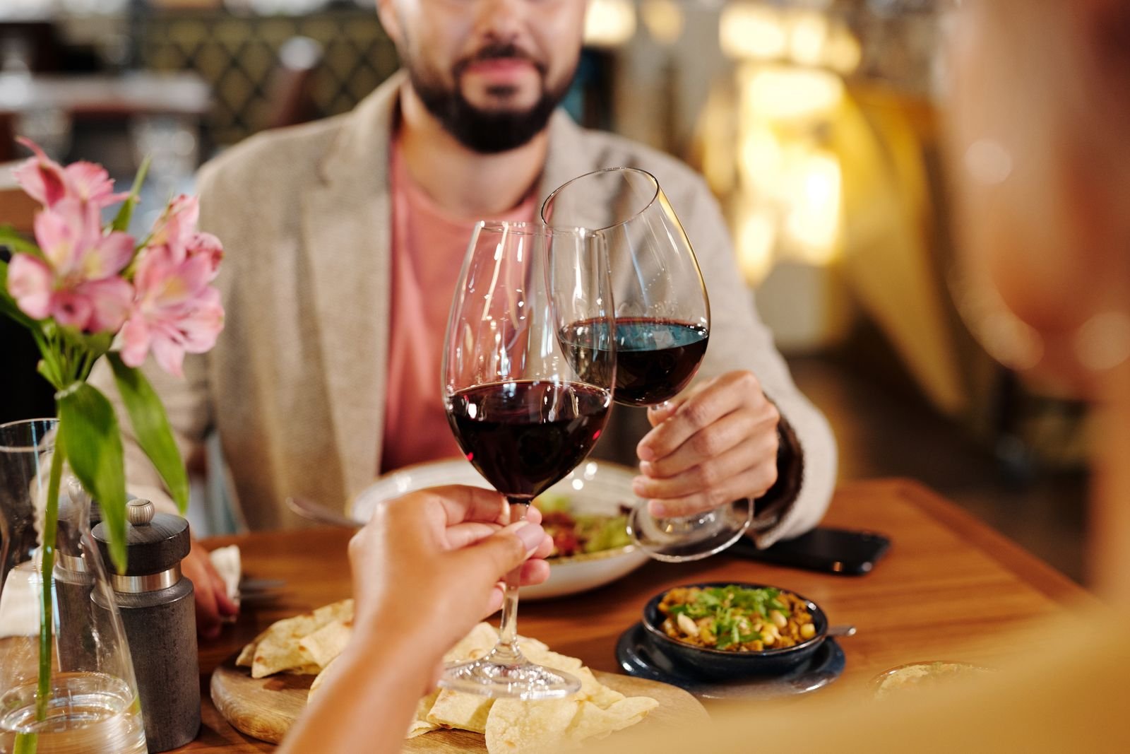 Pareja brindando con vino tinto durante una experiencia de enoturismo, un regalo para recordar