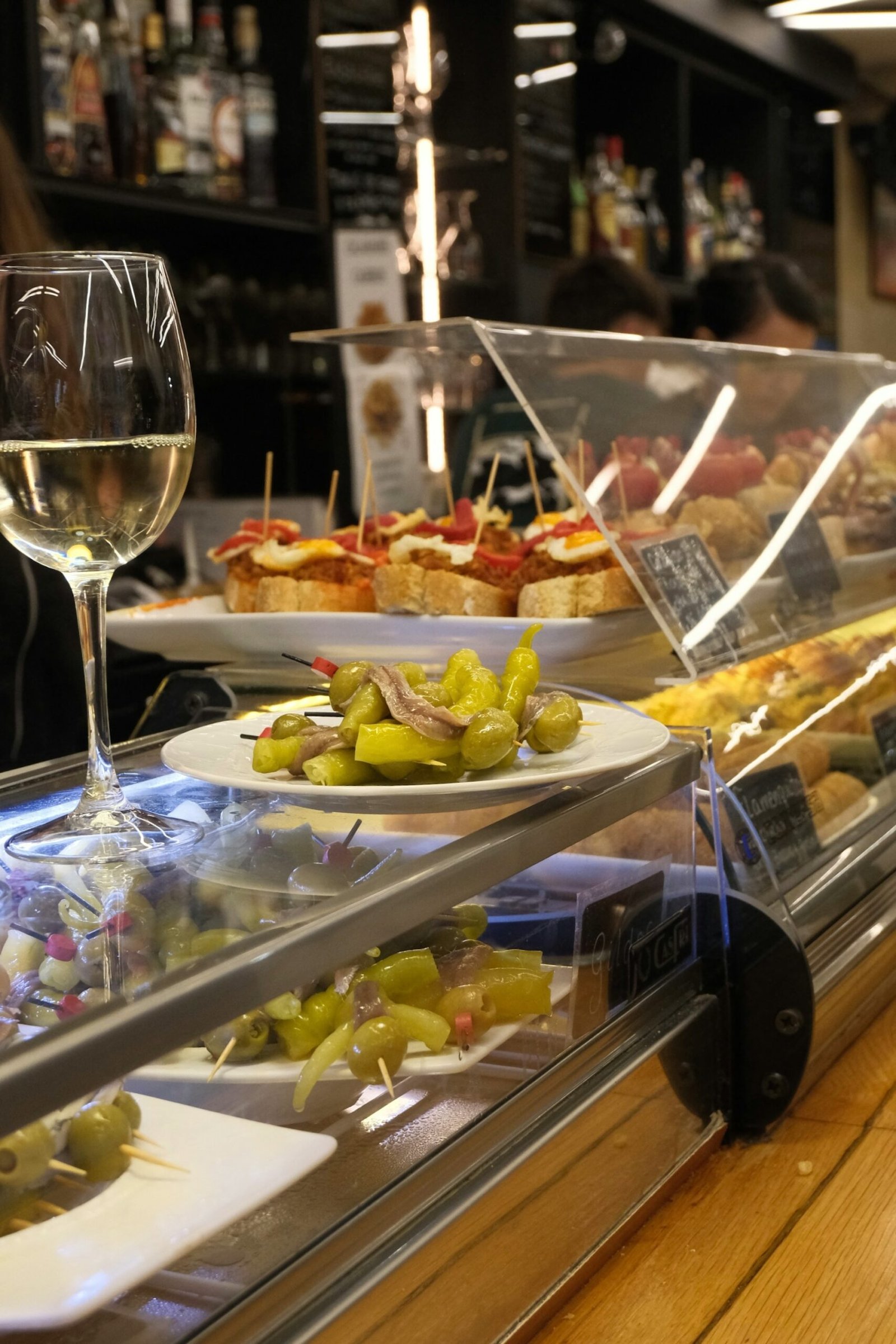Barra de tapas y pintxos españoles con banderillas y copa de vino