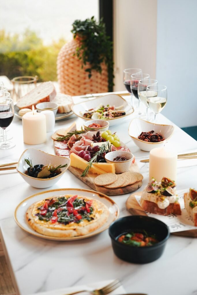 Mesa de picoteo de verano con tabla de embutidos, quesos, pan y copas de vino DO Utiel-Requena