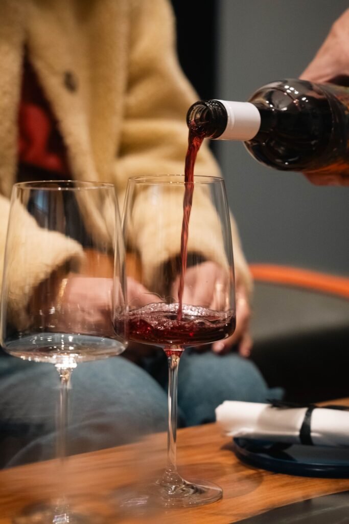 Sirviendo una copa de vino tinto para comprobar su aroma al abrir la botella