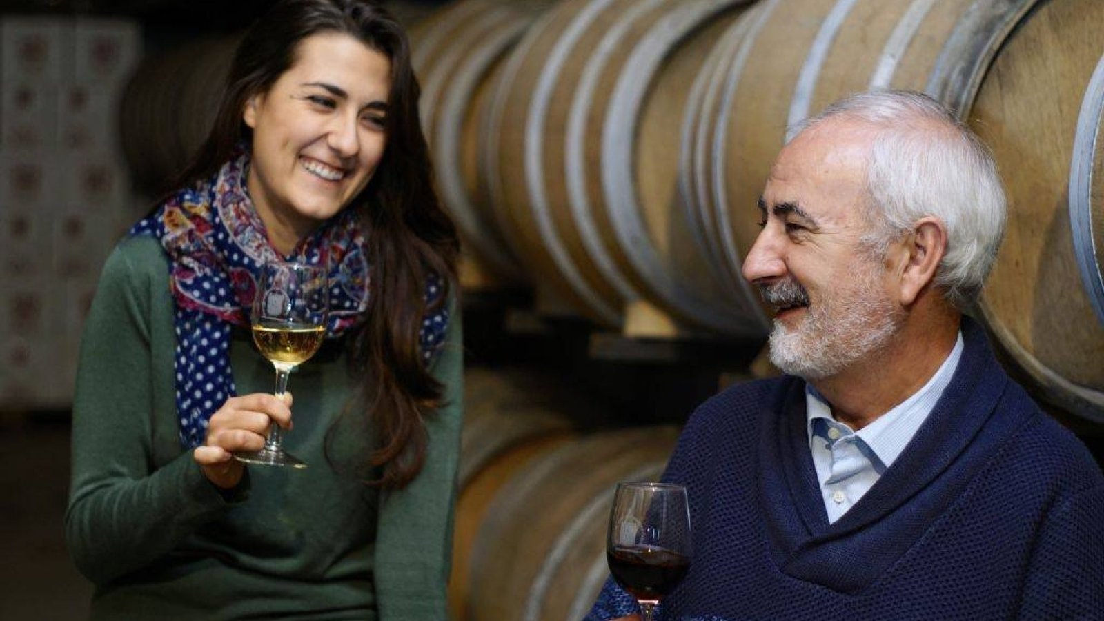 Visitantes catando vino junto a las barricas en una bodega de Utiel-Requena