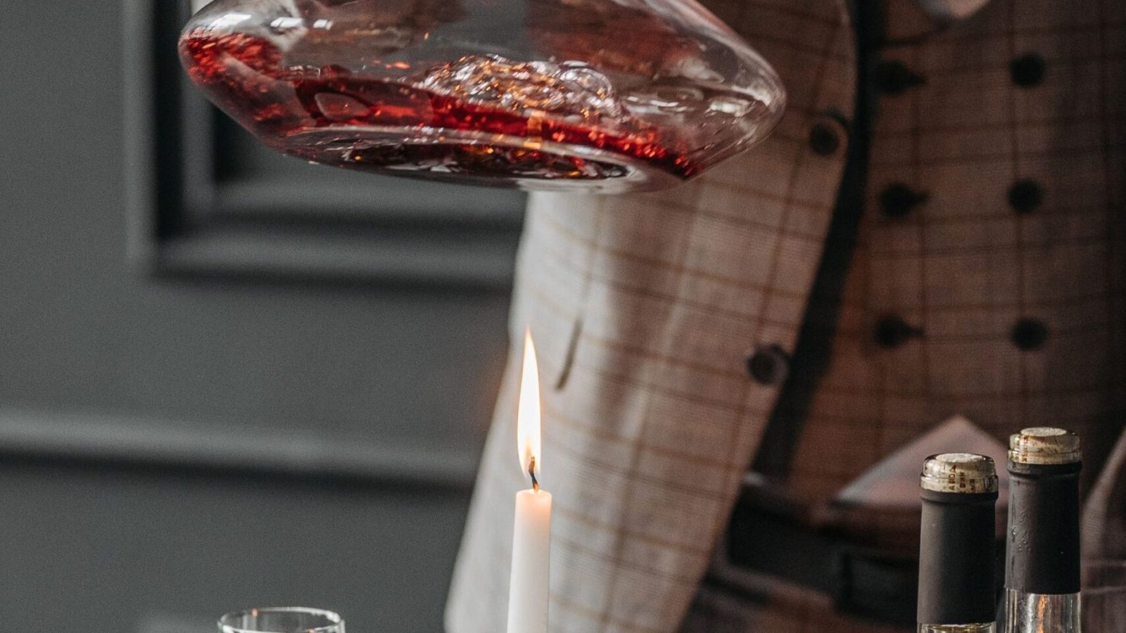 Vino tinto pasado a un decantador durante el ritual de decantar el vino