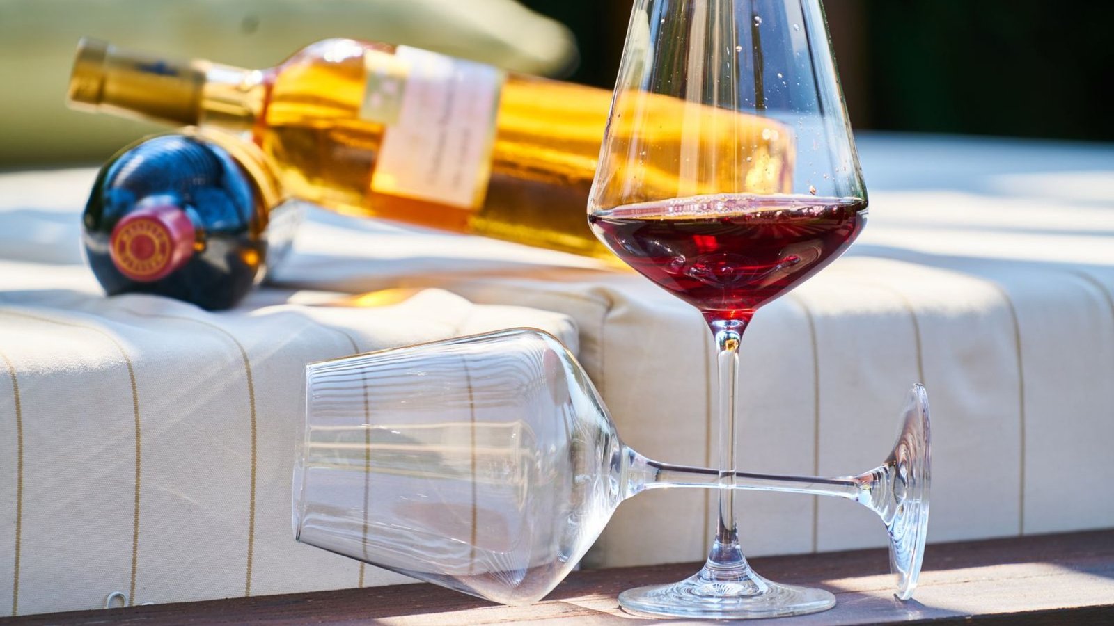 Copa de vino tinto a contraluz junto a la botella para comprobar su color