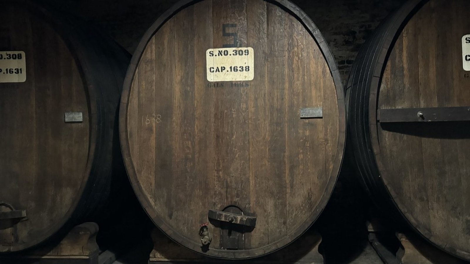 Barricas de roble envejeciendo vino en una bodega