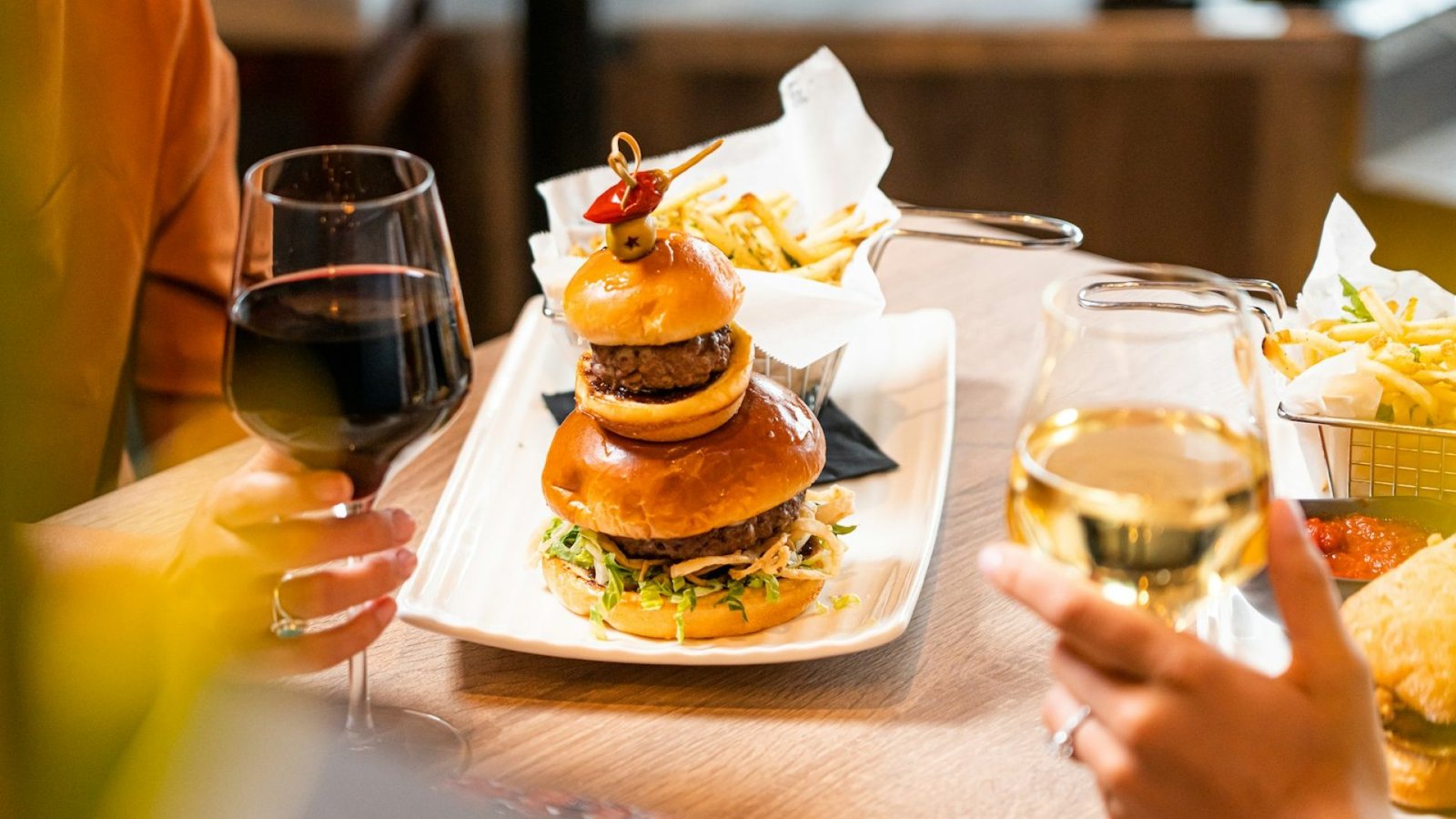 Hamburguesa casera con una copa de vino tinto en una mesa de verano